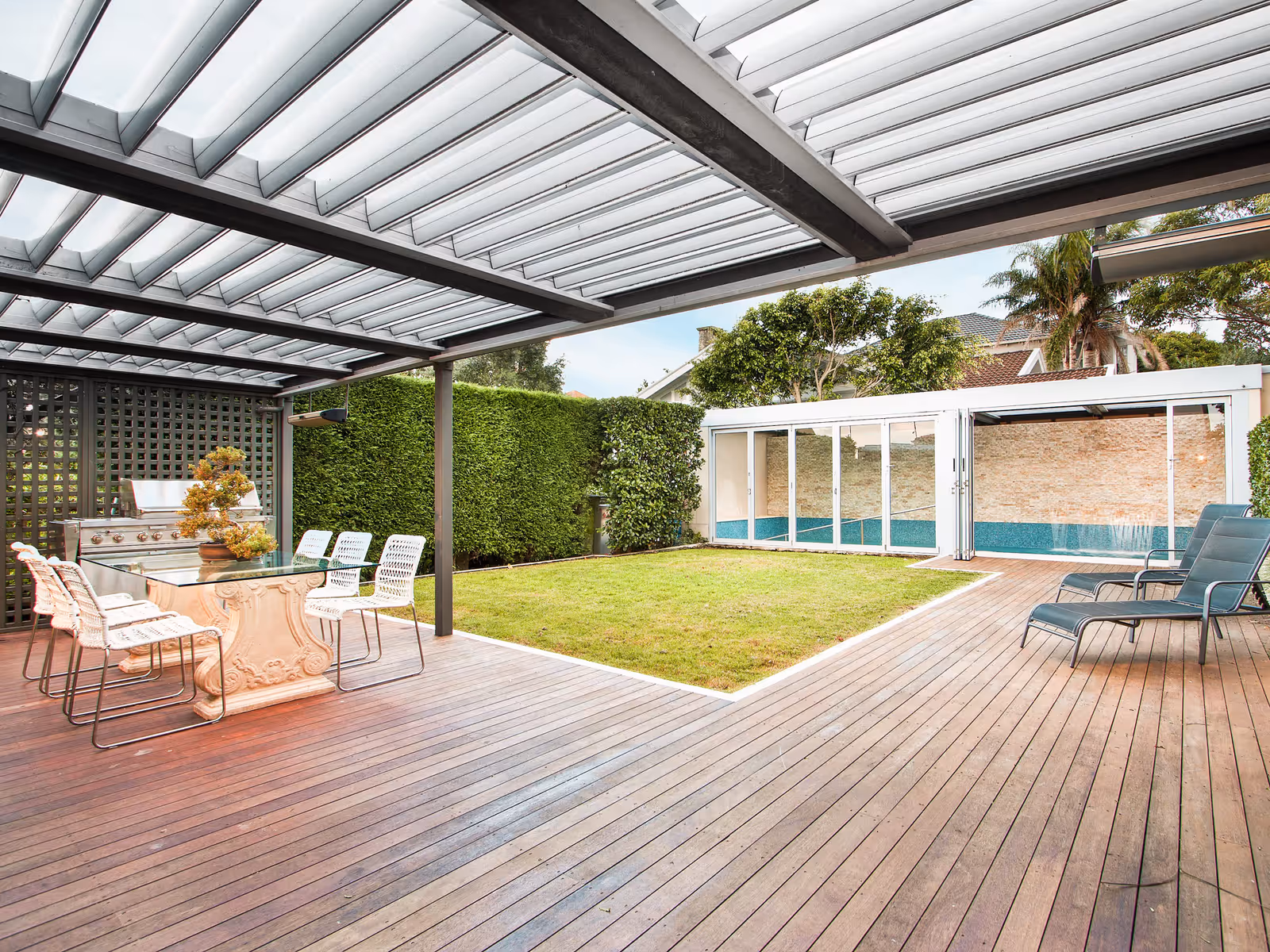 Patio residencial moderno con pérgola de aluminio, piscina y deck en el sur de Florida